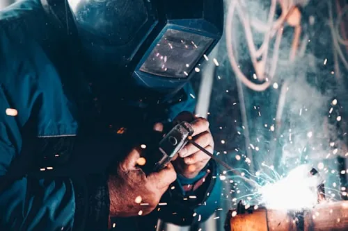 Üretim tesisinde metal kaynağı yapan usta
